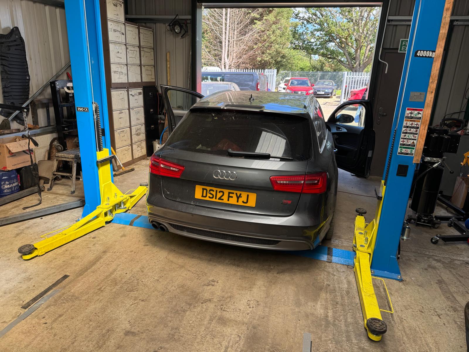 An Audi estate on the two-post lift inside the Godstone Cars workshop